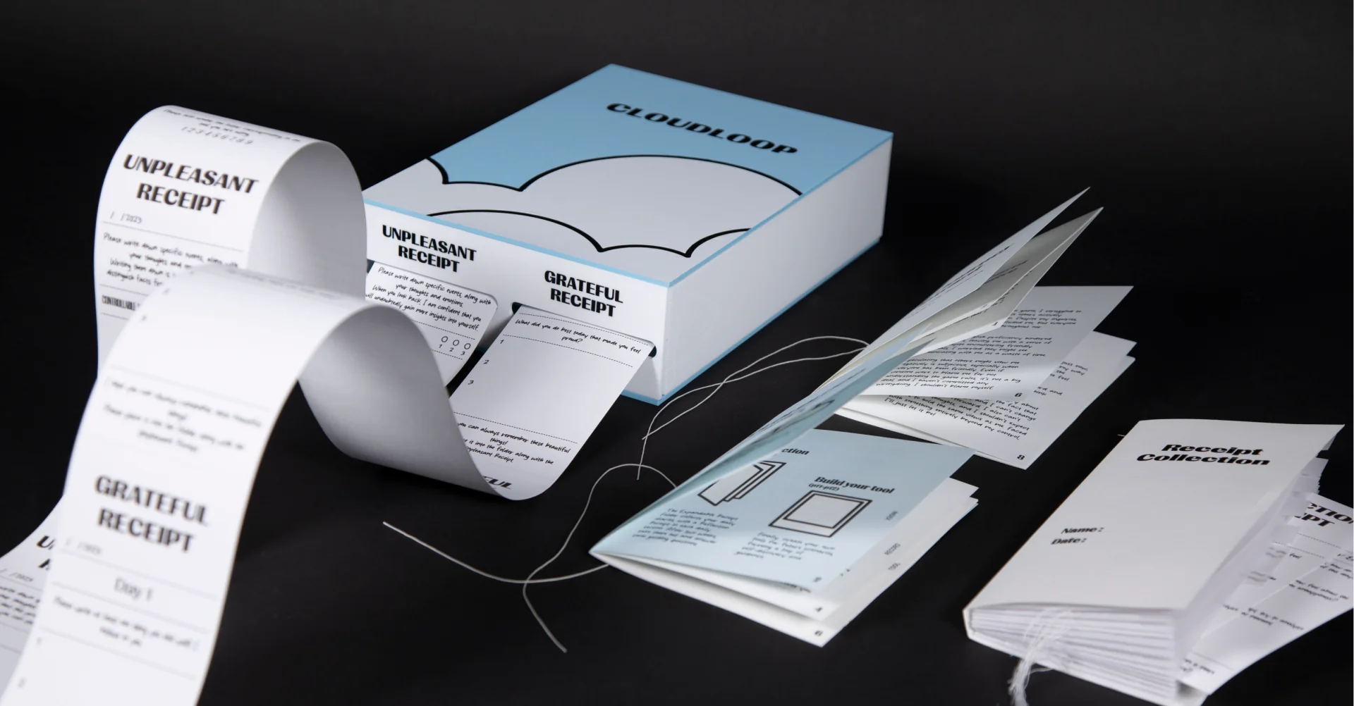 The Cloudloop toolkit: the receipt box with Unpleasant and Grateful receipts unrolling, the instructions, the My Journey Inward booklet and the receipt collection folder.