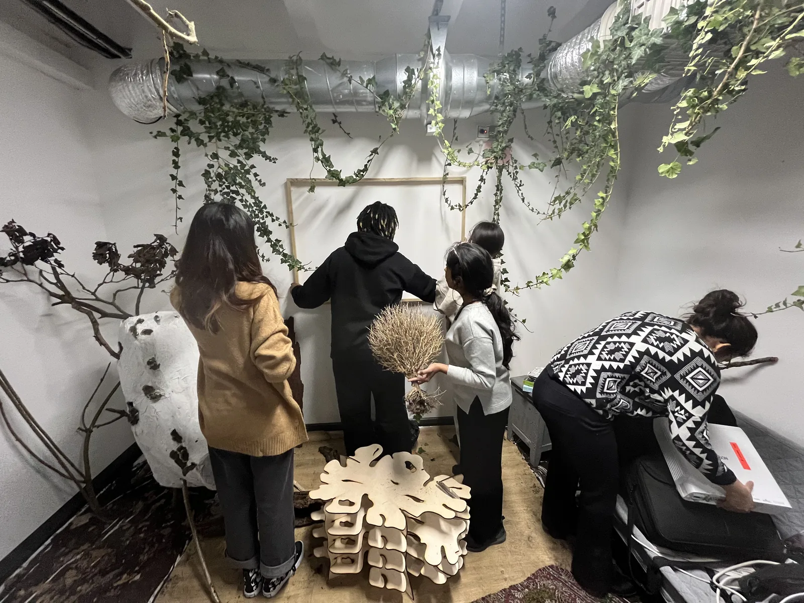 The team setting up the room with ivy and branches.